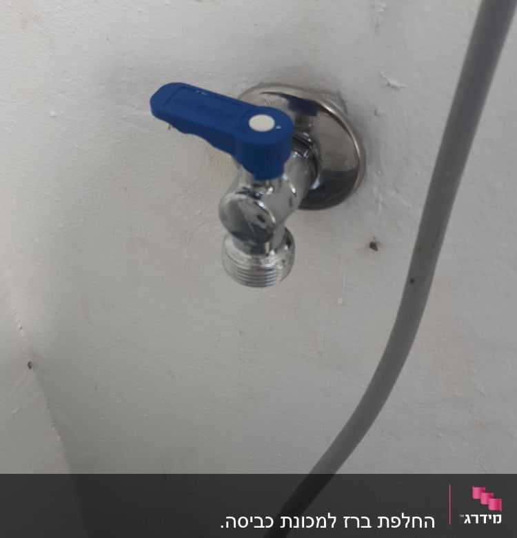 ברז מים עם ידית כחולה על קיר לבן